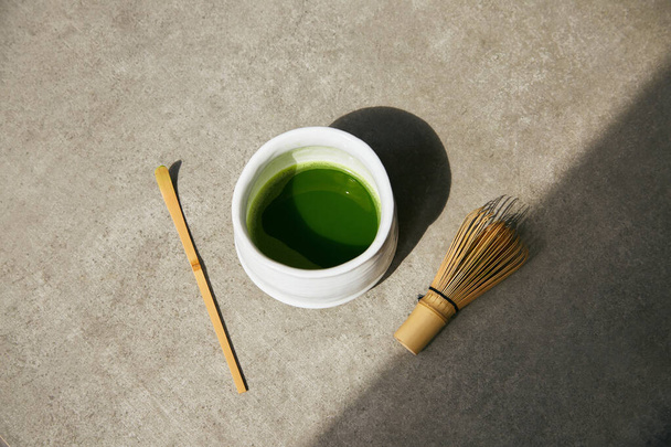Composição de chá matcha com sombra em uma superfície cinza
. - Foto, Imagem