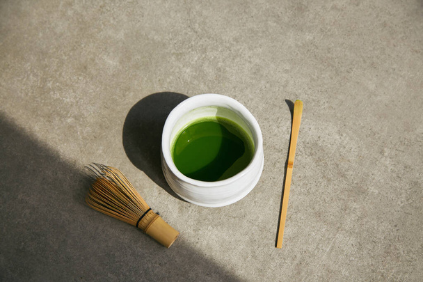 Verde orgánico té matcha y accesorios de té en la superficie gris
. - Foto, imagen