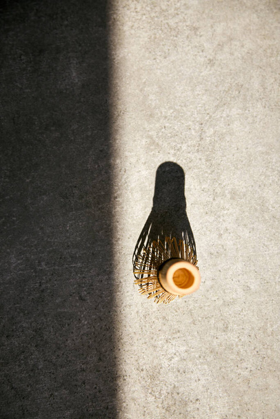 Matcha μπαμπού σύρμα και σκιά σε μια γκρίζα επιφάνεια. Άνω όψη. - Φωτογραφία, εικόνα