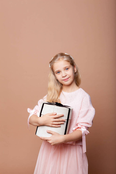 menina atraente segurando uma caixa de presente cilíndrica
 - Foto, Imagem