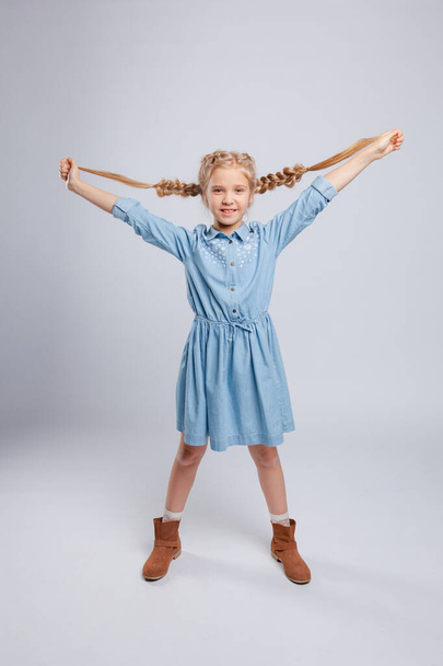 long-haired girl rejoices and holds herself for pigtails - Photo, image