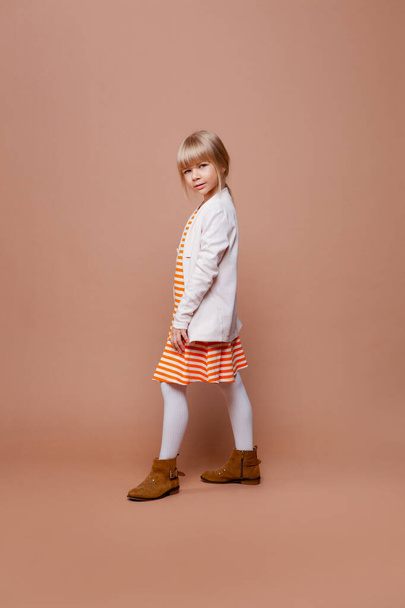 girl in daily autumn clothes on a beige background - Foto, Imagem