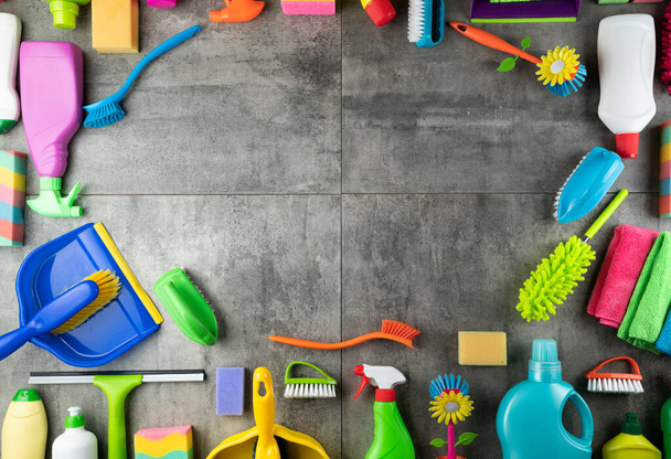 Spring house cleaning. Colorful cleaning kit on gray tiles floor. Top view. - Photo, Image