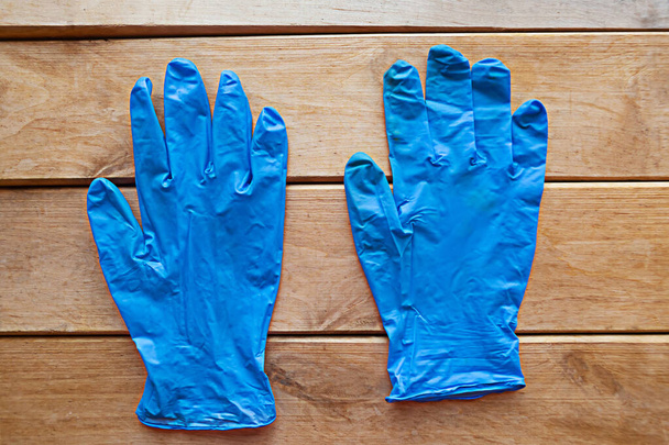 Латексные медицинские перчатки на деревянном фоне. Ковид-19
 - Фото, изображение