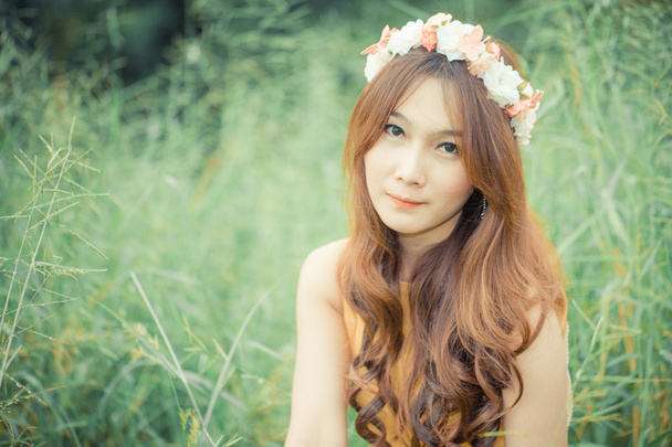 緑の芝生フィールド、牧草地に座っているアジアのタイの女性 - 写真・画像