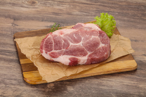 Steak de porc cru sur planche de bois prêt pour la cuisson - Photo, image