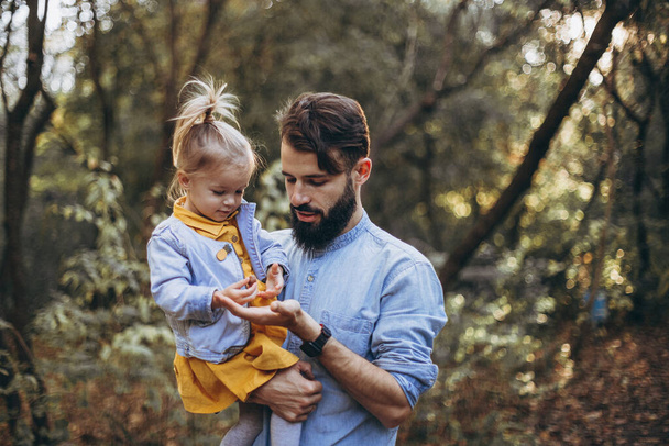 01.06.2019 Vinnitsa, Ukraine: young, stylish bearded father walking with his little daughter in nature at sunset. Family photos of father and one child. selective focus, noise effect - Foto, imagen