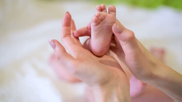 Mutter berührt sanft Babys Füße. Frau macht taktile Fußmassage für Baby. Nahaufnahme. - Filmmaterial, Video