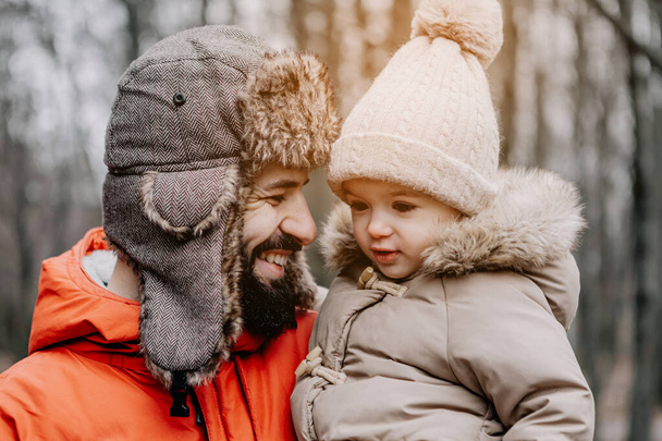 Portrait of happy family: Father and baby daughter on Winter Vacation in park. Happy, joyful family. - Valokuva, kuva