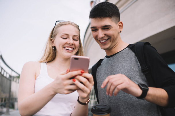 Cheerful male and female users of smart technology checking article with good news about last notification for mobile generation, happy man and woman feeling good from successful cellphone updating - Valokuva, kuva