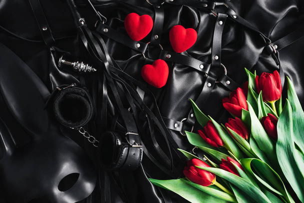 w Walentynki, zestaw zabawek dla dorosłych czarne tło jedwabne. czerwony tulipan - Zdjęcie, obraz