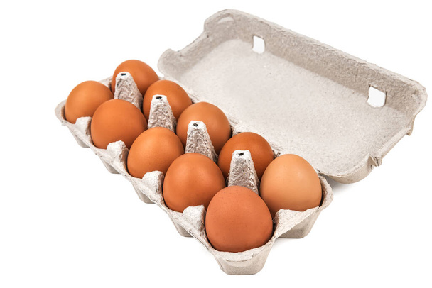 tien eieren in een papieren bakje, eierdoos geïsoleerd op wit - Foto, afbeelding