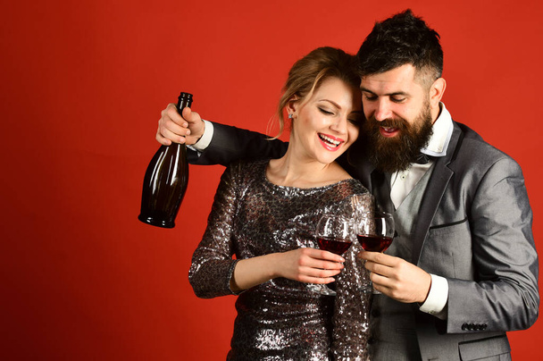 Lady and gentleman celebrating with merlot. Woman in sparkling dress - Foto, Imagen