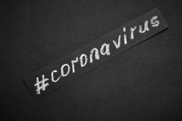 Заголовок коронавируса написан на черном бумажном фоне с мелом
. - Фото, изображение