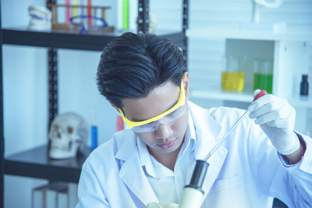 Азіатський молодий вчений досліджує і перевіряє використання хімічних речовин для виробництва. Дивіться тестові трубки в наукових лабораторіях, винаходах і науково-дослідних концепціях. - Фото, зображення