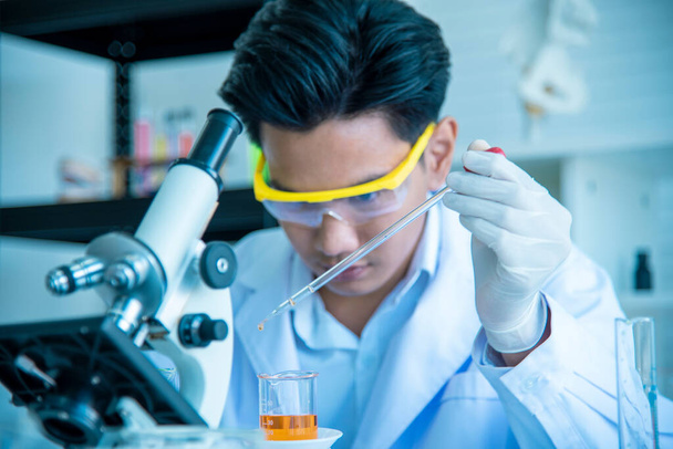 Un jeune scientifique asiatique étudie et teste l'utilisation de produits chimiques pour la production. Voir tubes à essai dans les laboratoires scientifiques, inventions et concepts de recherche
. - Photo, image