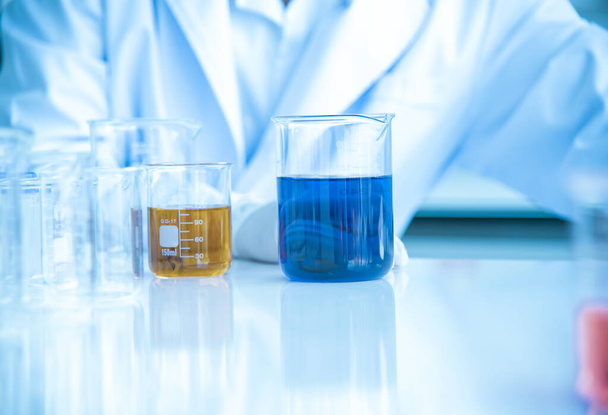 Tesztcsövek és oldatfőzőpoharak egy tudományos laboratóriumban többszínű folyadékkal a laboratóriumi asztalon kémiai háttérnek Koncepció Keresés - Fotó, kép