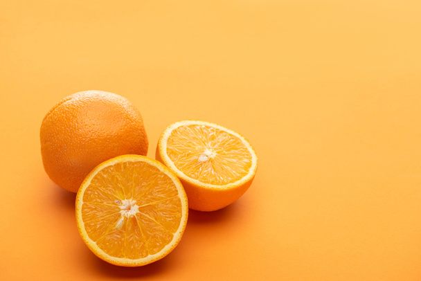 érett finom vágott és egész narancs színes háttér - Fotó, kép