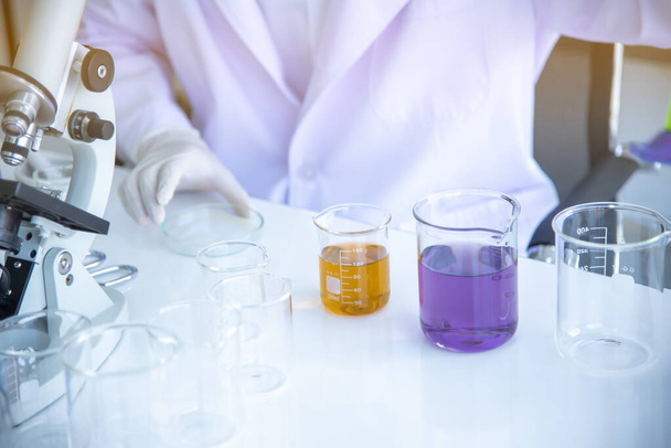 Test tubes and solution beakers in science laboratory with amulticolored liquid on the laboratory table for chemical background Concept Search - Foto, Imagen