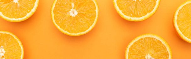 top view of ripe juicy orange slices on colorful background, panoramic crop - 写真・画像