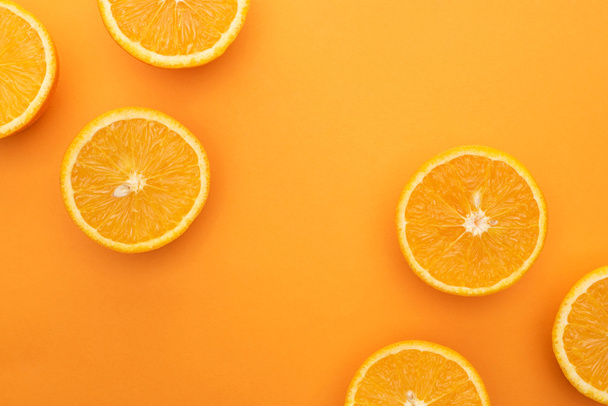 top view of ripe juicy orange slices on colorful background - Zdjęcie, obraz