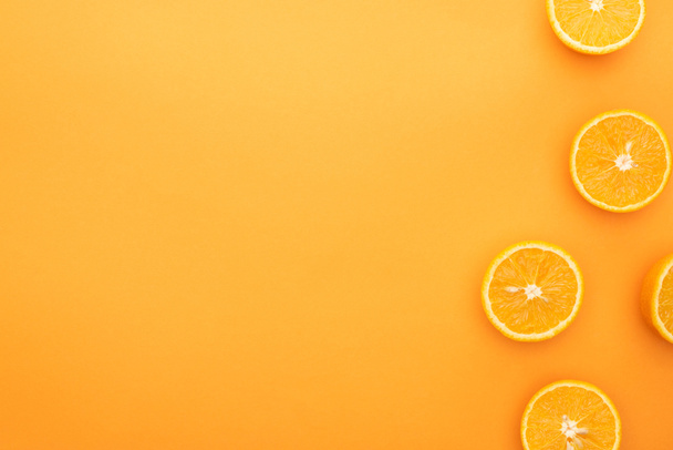 top view of juicy orange slices on colorful background - Foto, afbeelding
