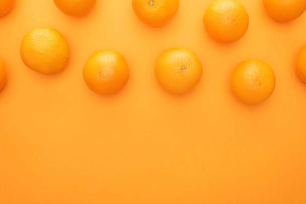 top view of ripe juicy whole oranges on colorful background - Foto, imagen