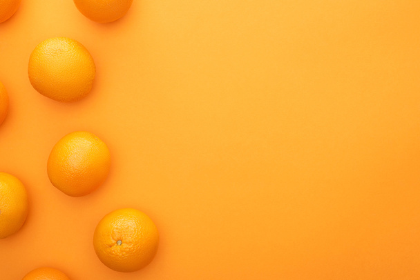 horní pohled na zralé šťavnaté celé pomeranče na barevném pozadí s kopírovacím prostorem - Fotografie, Obrázek