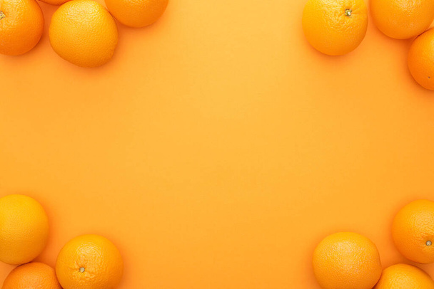 Draufsicht auf reife saftige ganze Orangen auf buntem Hintergrund mit Kopierraum - Foto, Bild