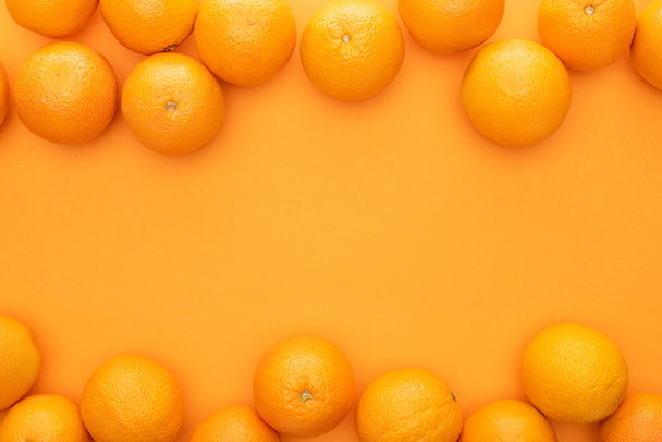 top view of ripe juicy whole oranges on colorful background with copy space - Fotografie, Obrázek
