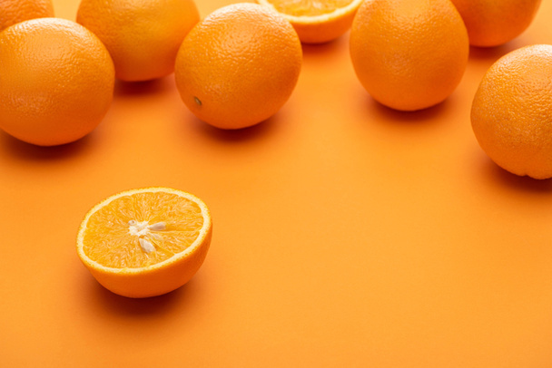 ripe juicy whole and cut oranges on colorful background - 写真・画像