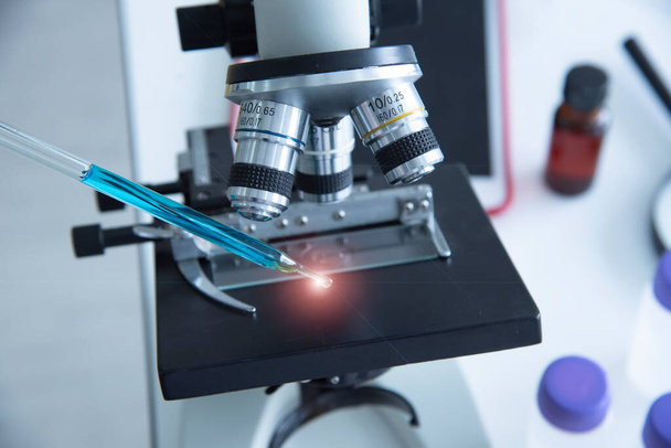 Μικροσκόπια και δοκιμαστικοί σωλήνες Γυάλινα σκεύη που περιέχουν πολλές χημικές ουσίες στο εργαστήριο - Φωτογραφία, εικόνα