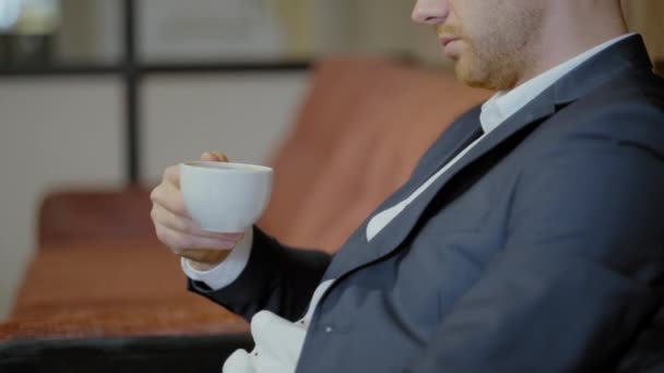 Two men in suits sit in a restaurant. A business meeting. Men drink coffee and talks. - Materiał filmowy, wideo