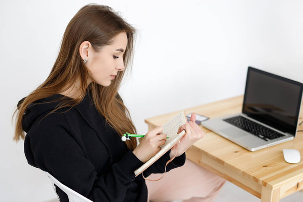 Умная молодая женщина довольна изучением языка во время онлайн-курсов с помощью нетбука, улыбающаяся студентка с ноутбуком делает домашнюю работу, блоггер ищет информацию в Интернете
 - Фото, изображение