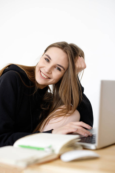 Fiksu nuori nainen tyytyväinen kieltenoppimiseen verkkokurssien aikana nettikirjan avulla, hymyilevä opiskelija, jolla on muistikirja tekemässä kotitehtäviään, bloggaaja etsii tietoa Internetistä
 - Valokuva, kuva
