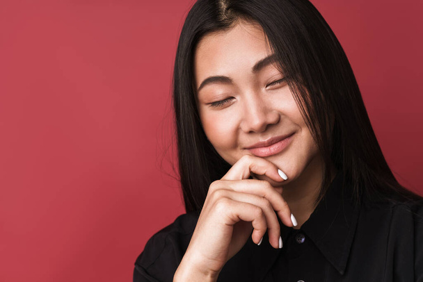 Close up of a pretty smiling young asian woman wearing casual clothes standing isolated over red background - Fotoğraf, Görsel