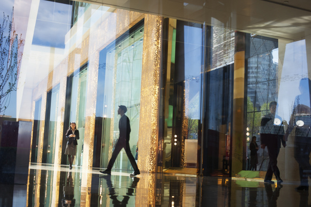 Liikemiehet kävelemässä toimistorakennuksen aulassa
 - Valokuva, kuva