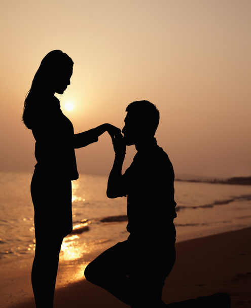 Silhouette de copain agenouillé et embrassant sa main de copines
 - Photo, image