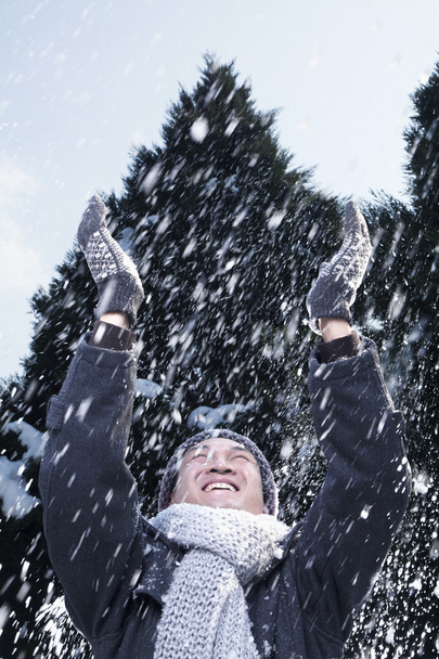 Mann mit erhobenen Armen spürt den Schnee - Foto, Bild