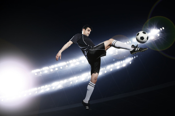 futballista a levegõben rúg a futball-labda - Fotó, kép