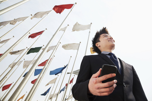 Бизнесмен держит телефон с флагами
 - Фото, изображение