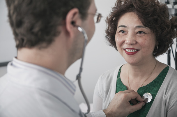 Doctor checking heartbeat of a patient - Photo, Image