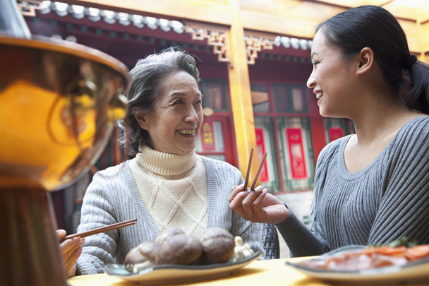 Äiti ja tytär nauttivat perinteisestä kiinalaisesta ateriasta
 - Valokuva, kuva