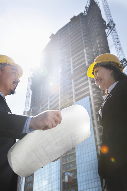 Two architects at a construction site holding blueprint - Photo, Image