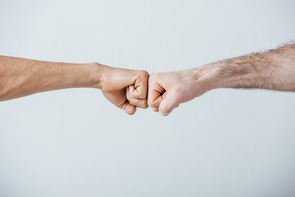 Cropped view of men doing fist bump isolated on grey  - Fotografie, Obrázek
