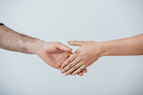 Oříznutý pohled na muže a ženu potřesení rukou izolované na šedé - Fotografie, Obrázek