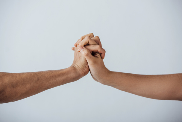 Обрізаний вид чоловіків, що тримають руки ізольовані на сірому
 - Фото, зображення
