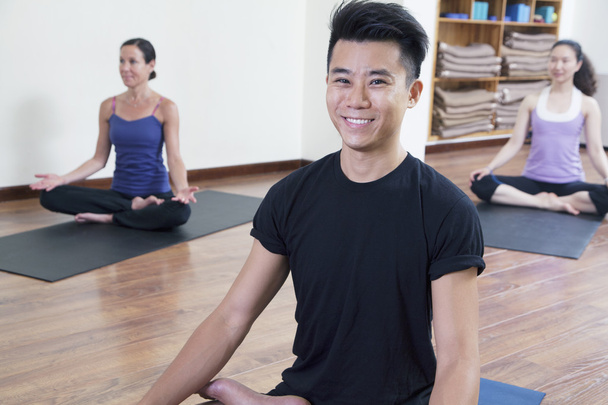 Hombre sentado con las piernas cruzadas en una clase de yoga
 - Foto, imagen