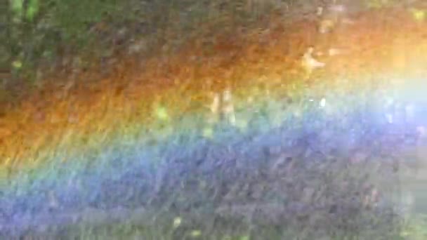 Arco-íris lindo brilhante close-up durante a chuva. Chuva artificial faz um grande arco-íris cor. Arco-íris de verão na chuva. O conceito de alegria, felicidade, humor de verão. Bandeira lgbt community
. - Filmagem, Vídeo