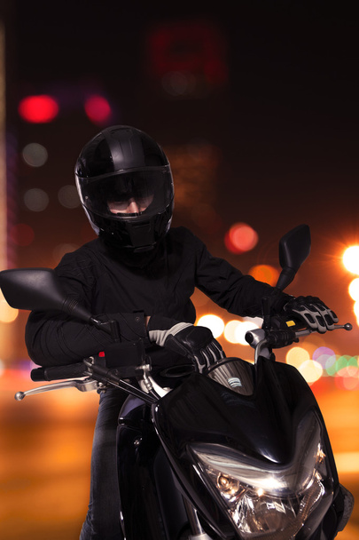 ο άνθρωπος που κάθεται στη μοτοσικλέτα του τη νύχτα - Φωτογραφία, εικόνα